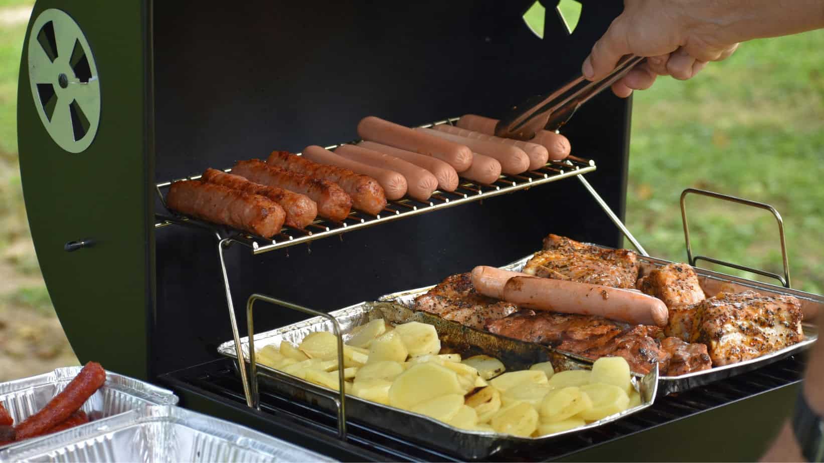 Fat Free Chicken Sausage: A Healthier Choice for the Modern Lifestyle 1 The image shows a portable grill or barbecue with various grilled items on it, including sausages, ribs, and what appears to be roasted potatoes.