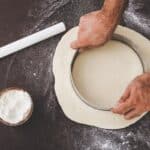 Person cutting dough with round cutter