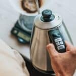 Person holding silver stainless steel electric kettle