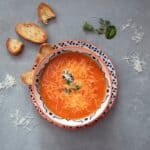 Orange soup on white and blue ceramic bowl