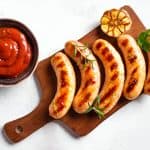 Grilled sausages with red sauce and roasted garlic