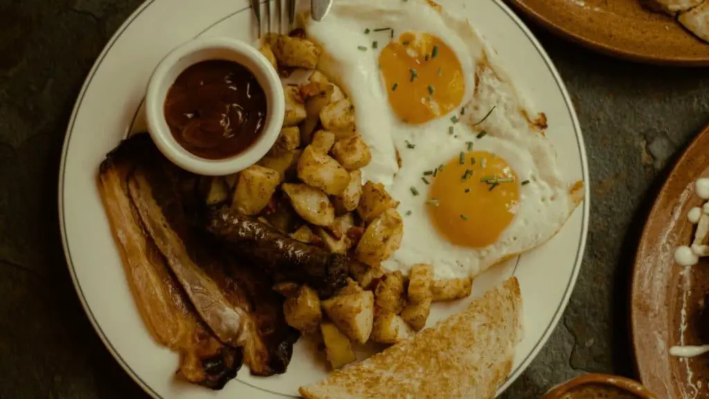 Savory chicken sausage hash with fried eggs and sides, a hearty and delicious breakfast dish.