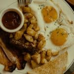 Savory chicken sausage hash with fried eggs and sides, a hearty and delicious breakfast dish.