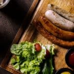 Juicy grilled chicken sausages with fresh salad greens and condiments, highlighting the cooking time for optimal results.