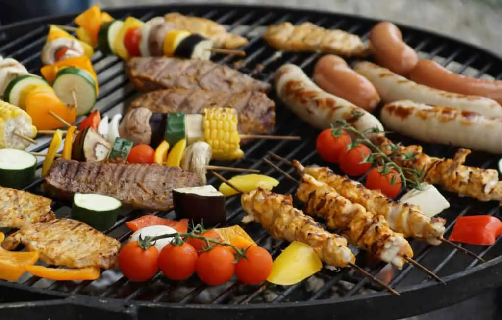 Grilling guide showing how to cook raw chicken sausage on grill alongside skewered veggies and meat cuts.