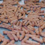A large spread of Chicken Sausage with Pork Casing on a metal tray, showcasing their brown, crispy texture.