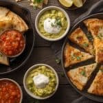 Crispy golden chicken sausage quesadillas served with vibrant salsa and creamy guacamole, creating a delightful Mexican-inspired dish with bold flavors.