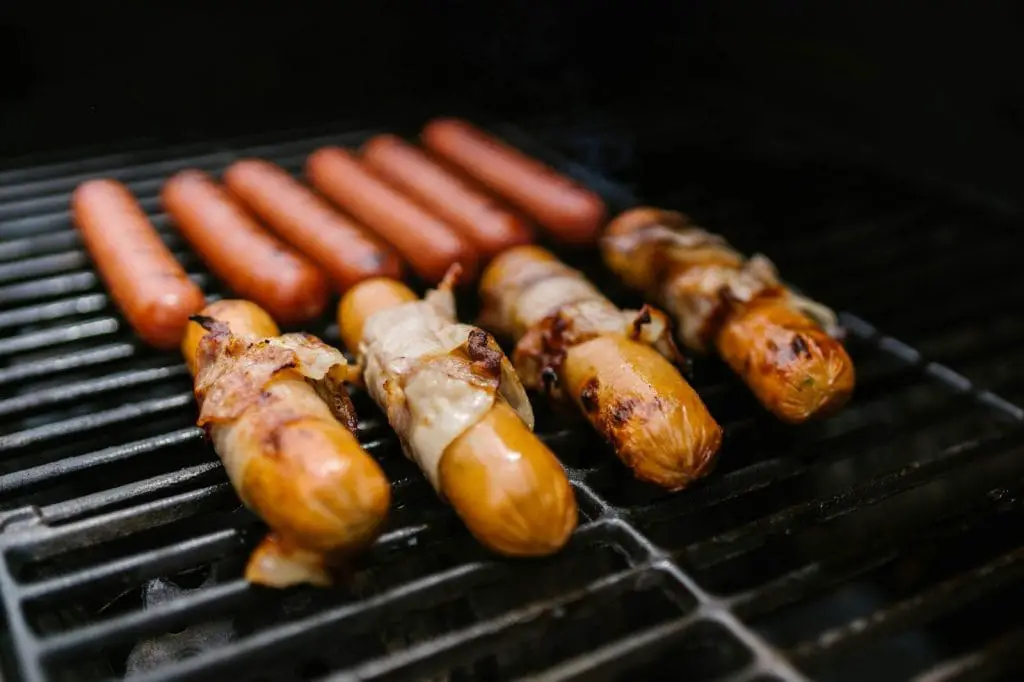 Grilled sausages and roasted vegetables on a grill, creating a tasty and smoky meal.