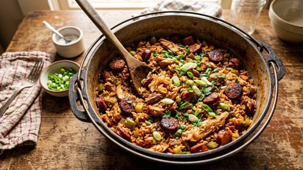 Cook The Restaurant's Food at Home 4 A pot of chicken and sausage jambalaya garnished with green onion, ready to serve